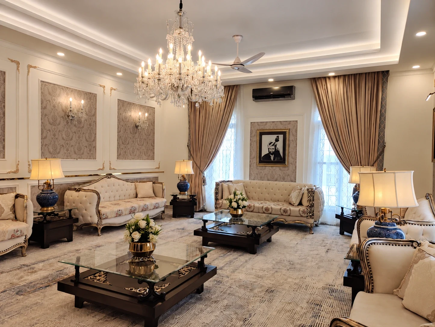 Wide room composition with chandelier and layered sofas.