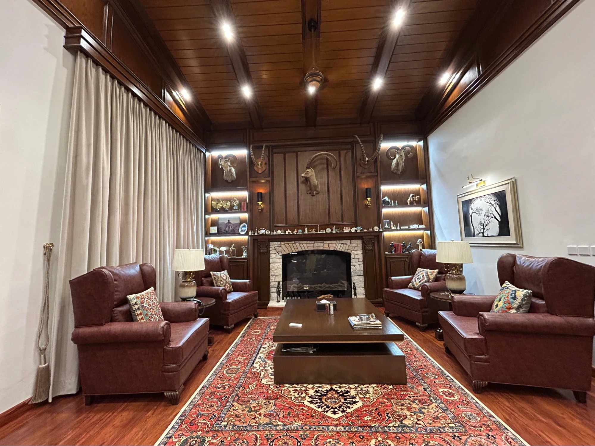Complete room with timber ceiling, fireplace and seating.