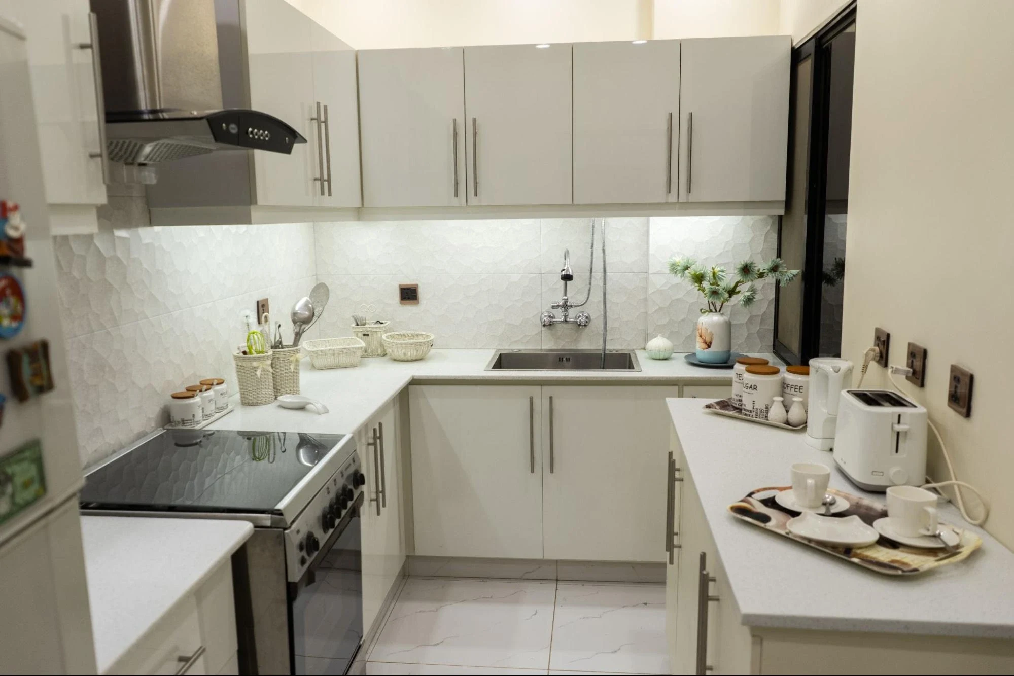 White cabinetry and a compact U-shaped kitchen.