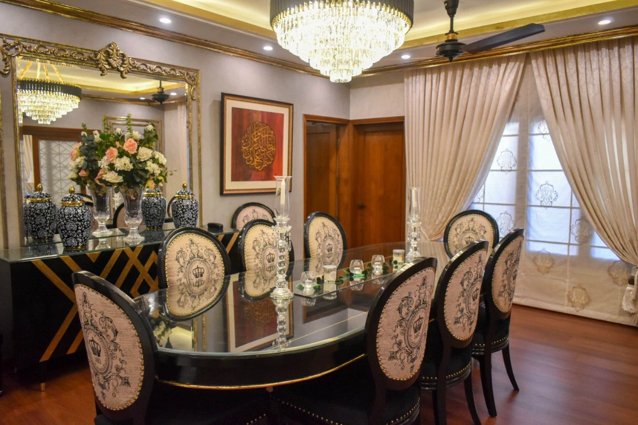 Full dining room with upholstered chairs and chandelier.