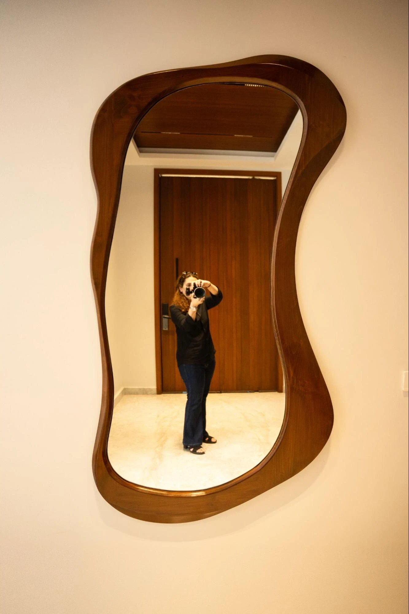 Freestanding image of a shaped timber mirror.